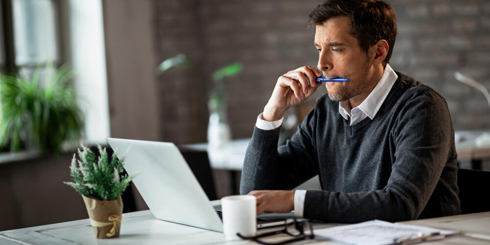 trabalhador-freelance-masculino-lendo-um-e-mail-enquanto-trabalhava-no-laptop-no-escritorio Insolvência de pequenas empresas: impactos e estratégia de superaçãoImagem de Drazen Zigic no Freepik