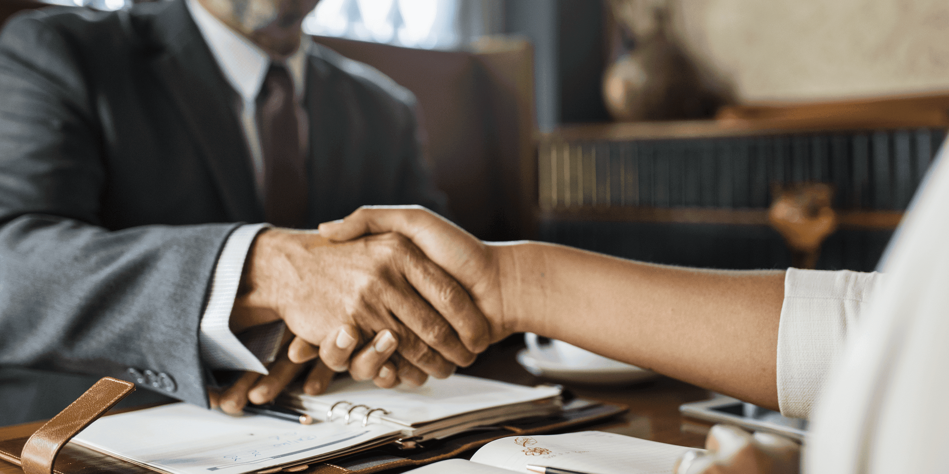 duas pessoas em um aperto de mão num escritório representando recuperação judicial