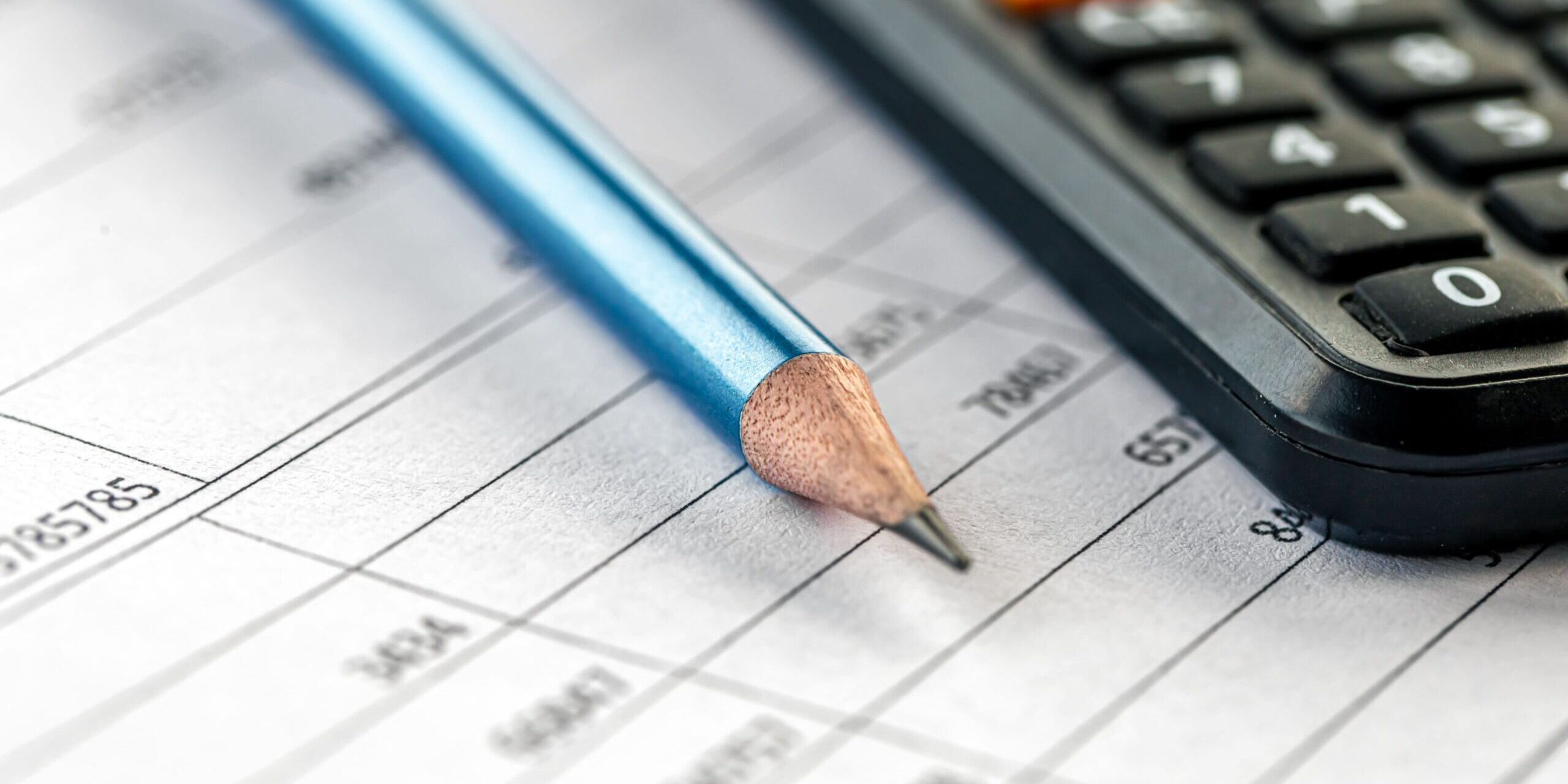 lápis, calculadora e papel para ilustrar tema do efeito do PL 3/24 sobre o processo falimentar