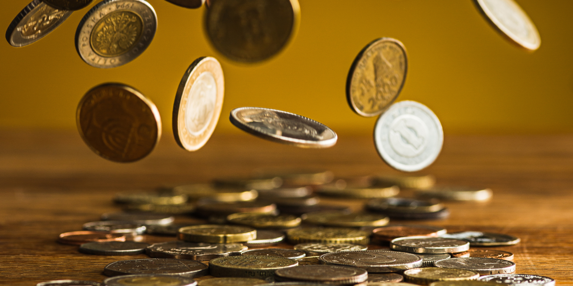 seguro-investir-empresas-recuperação-judicial moedas caindo para ilustrar o tema com a pergunta: é seguro investir em empresas em recuperação judicial?